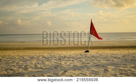 Flag on a beach with golden sunset
