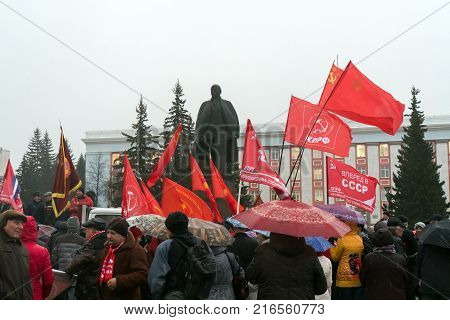 IZYUM Russia - November 7 2017. Red flag of Communist party of Ukraine against a monument to Lenin. Monument to Vladimir Ulyanov Lenin and flag of Communist party of Russia.