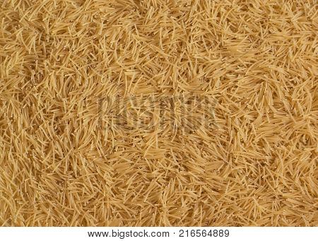 Scattered uncooked dry vermicelli texture background close-up