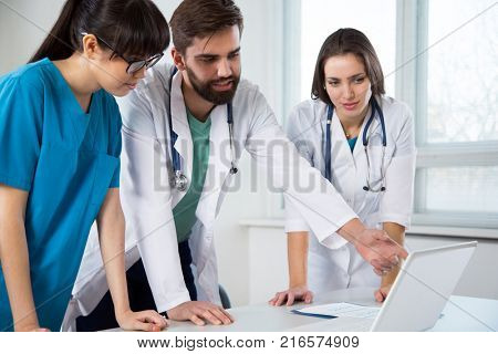 Group of doctors in the clinic discuss the diagnos of the patient