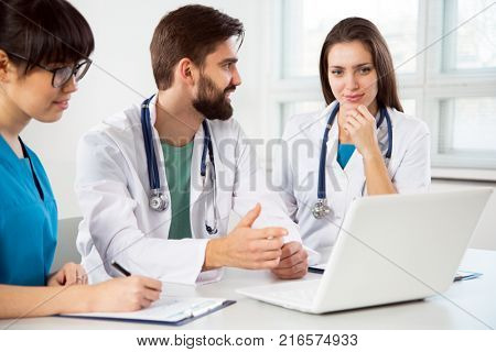 Group of doctors in the clinic discuss the diagnos of the patient