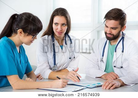 Group of doctors in the clinic discuss the diagnos of the patient