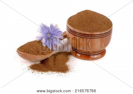 chicory powder in a bowl and spoon with a flower isolated on white background.