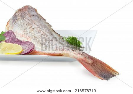 Fragment of the large square dish with uncooked red cod sliced lemon and red onion dill at shallow depth of field on a white background