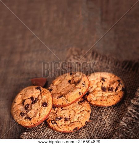 Chocolate cookies on dark napkin on wooden table macro top view