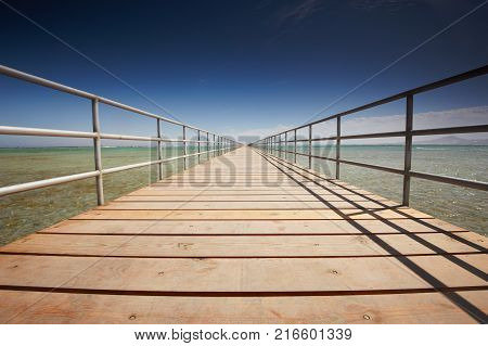 Long wooden jetty on the Red Sea. Pontoon jetty. Egypt.