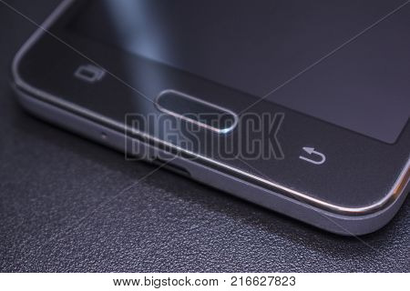 Touch smartphone in black on a black matte background.