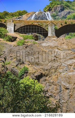 Railroad bridge over the Dudhsagar Waterfall in the tropical jungle of India.