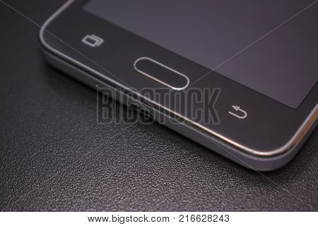 Touch smartphone in black on a black matte background.