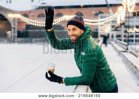 Outdoor Shot Of Unexperienced Male Skater Uses Skate Aid For Go Skating On Ice, Being In Good Mood,