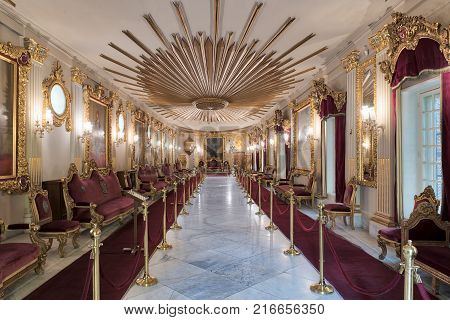 Cairo, Egypt - December 2, 2017: Throne Hall at Manial Palace of Prince Mohammed Ali Tewfik with ornate ceiling inspired by the old flag of the ottoman empire gold plated armchairs and red carpets Cairo Egypt