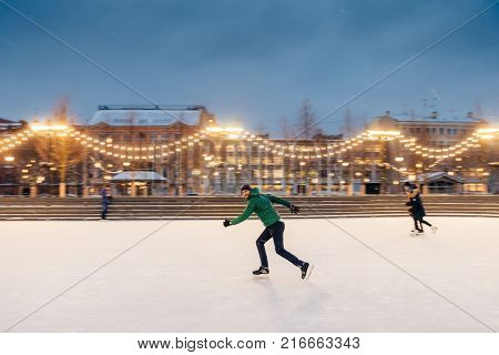 Young Male Begginer Learns Skating With Help Of Special Figure, Leans At It, Being On Ice Rink Cover