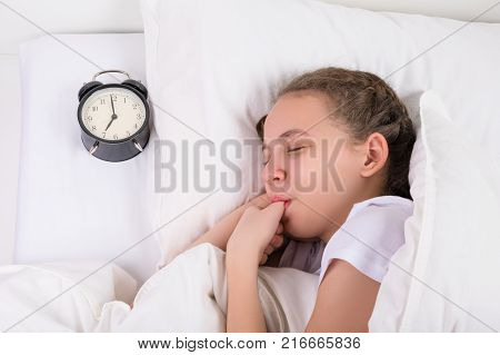 girl sleeps and sucks her thumb a habit since childhood