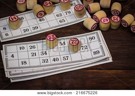On A Wooden Bingo Table Game, A Cup With A Coffee, A Biscuit And An Orange Slice