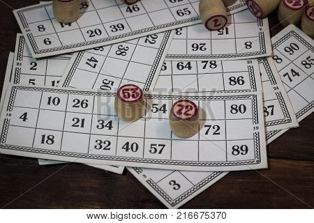 On A Wooden Bingo Table Game, A Cup With A Coffee, A Biscuit And An Orange Slice