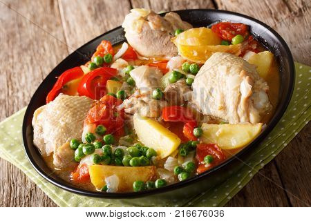 Pieces Of Chicken Stew With Potatoes, Peppers, Tomatoes, Peas And Onions Close-up. Vertical Top View
