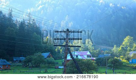View of the rural path and pole at forest in the autumn day