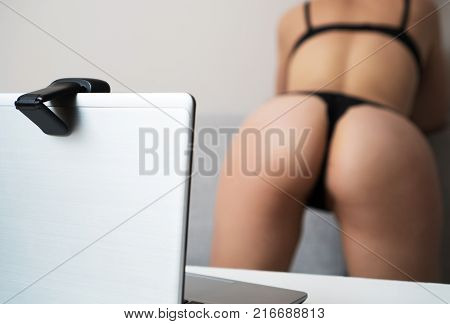 Seductive woman working as webcam model. Shows ass.