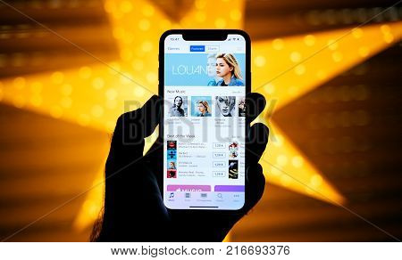 Paris France - Nov 10 2017: Man Holding The New Apple Iphone X 10 Display With Yellow Star Bokeh Bac