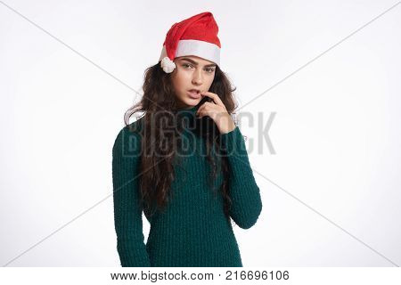 woman in green dress holds a hand near the mouth, christmas, winter, new year.