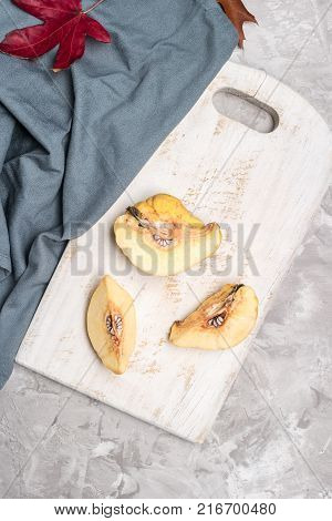 Quince fruit parts on concrete kitchen countertop.