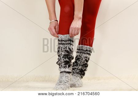 Winter fashion. Woman legs wearing fashionable wintertime clothes woolen warm socks and red tights