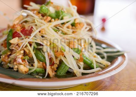 SOM-TAM Thai delicious raw papaya salad with unique taste hot and spicy this dish with tomato and crab. Papaya salad with red chili.