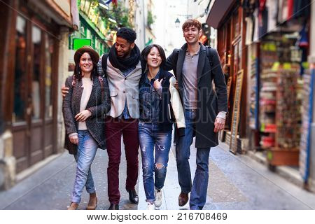 Multi-ethnic group of friends having fun in Paris, Latin Quarter, near Notre Dame Cathedral.