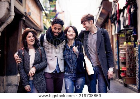 Multi-ethnic group of friends having fun in Paris, Latin Quarter, near Notre Dame Cathedral.