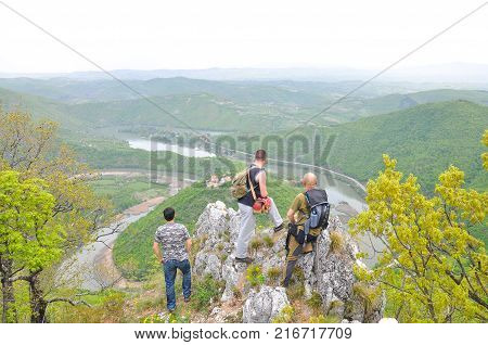 Hikers on top of a mountain enjoy the beautiful view of nature, forest and river in valley. View on meanders of Morava river  from Kablar, Serbia