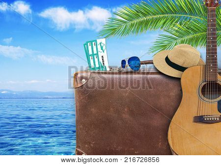 Concept of summer traveling with old suitcase and guitar