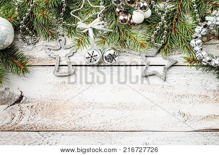 Christmas composition with fir tree branches and christmas decorations on white wooden background, top view with copy space