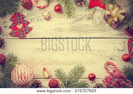 Christmas composition with fir tree branches and red christmas decorations on white wooden background, top view with copy space