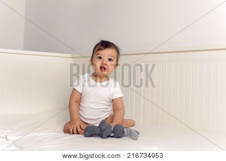 boy baby t-shirt lies under a blanket in a big white bed
