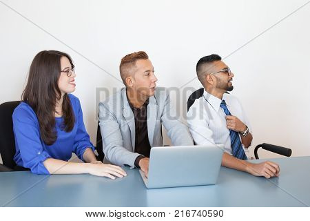 Conference participants listening to business lecture at training class. Positive young people studying in business school. Cheerful colleagues listening to annual report at meeting. Education concept