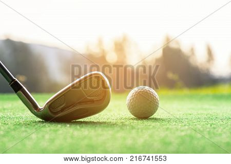 Asian woman Golf player hit swing shot golf ball on the green sunset eventing time. Healthy and Lifestyle Concept.