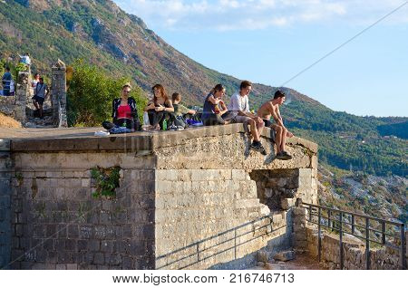 KOTOR MONTENEGRO - SEPTEMBER 8 2017: Unknown tourists are on ruins of fortress of St. John (Illyrian Fort) over city of Kotor Montenegro