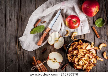 Homemade sun-dried organic apple slices crispy apple chips on an old rustic wooden table with fresh apple and cinnamon. Copy space top view