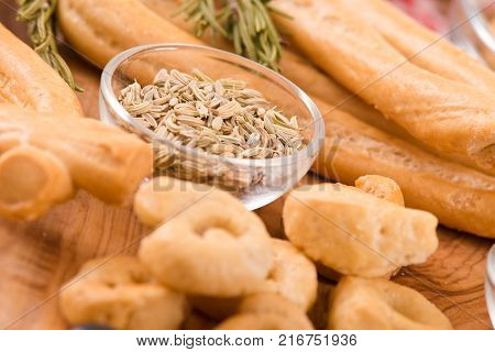 Italian taralli with spices on wooden table.