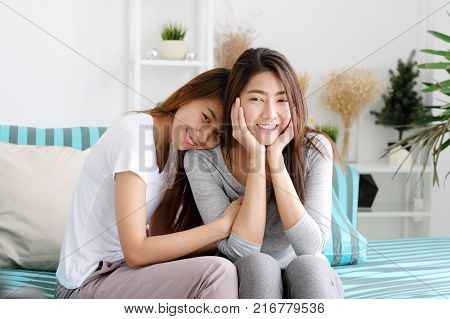 Young cute asia lesbian couple happy moment while sitting on spfa in living room lgbt homosexual lesbian couple lifestyle