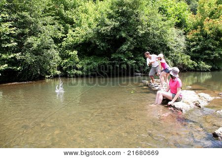 Famiglia giocare a ricochet nel fiume
