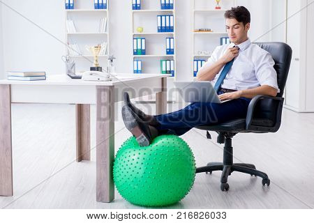 Young businessman doing sports stretching at workplace
