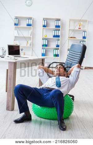 Young businessman doing sports stretching at workplace