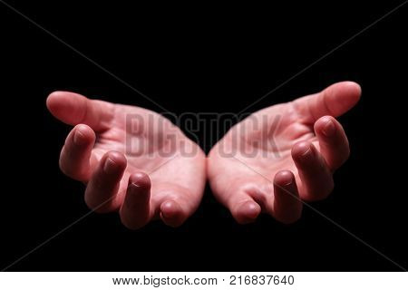 Woman hands cupped in a welcoming, accepting, offering, giving, begging, receiving gesture. Also for praying, prayer, welcome, accept, give, receive, protect, concept. Black background, front view