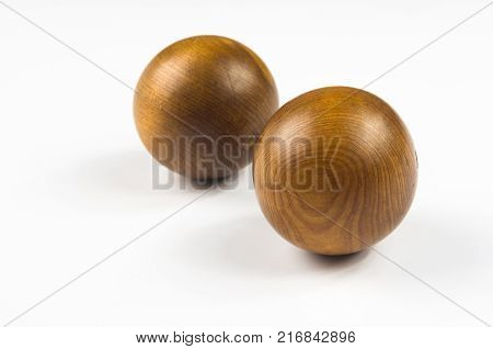pair of wooden Chinese singing balls Baoding of health for hands on white background
