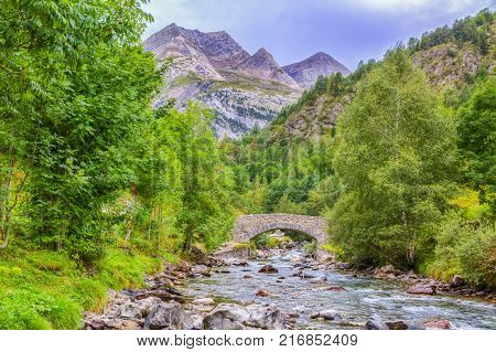 Image of a stone bridge over the River Gave de Gavarnie few kilometers downstream of the Cirque de Gavarnie in Pyrenees Mountains.
