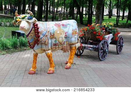 Smolensk, Russia - July 12, 2011: A decorative cow with cart in the city park of Smolensk