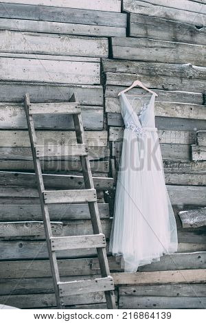 A Beautiful Dress Of Gray Hanging On A Hanger On A Wooden Background