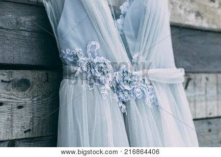 A Beautiful Dress Of Gray Hanging On A Hanger On A Wooden Background