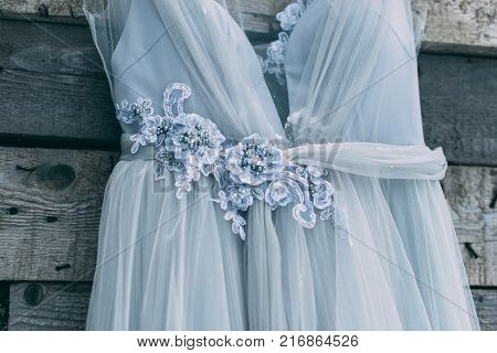 A Beautiful Dress Of Gray Hanging On A Hanger On A Wooden Background